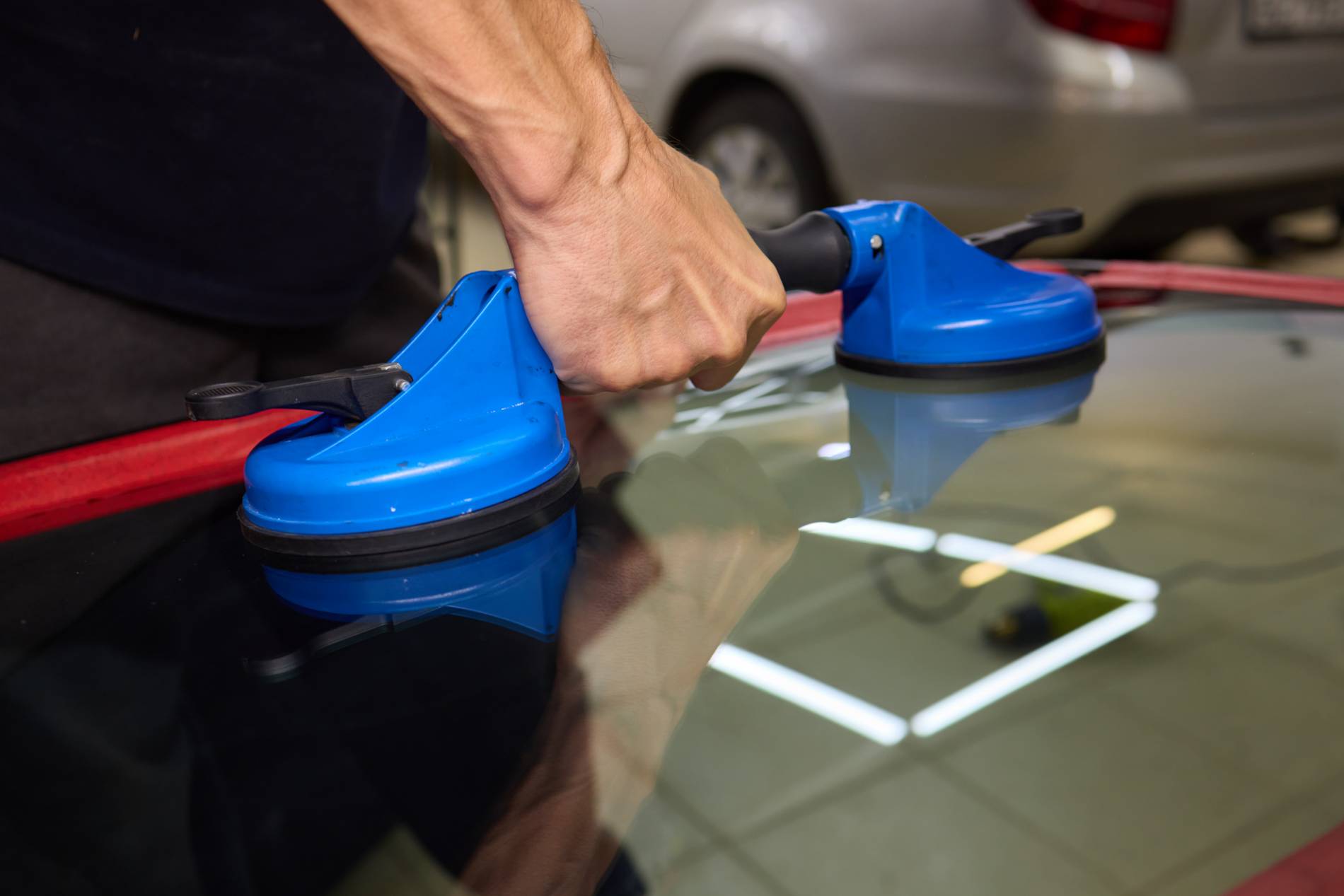 Pose d’un pare-brise automobile à l’aide de ventouses professionnelles